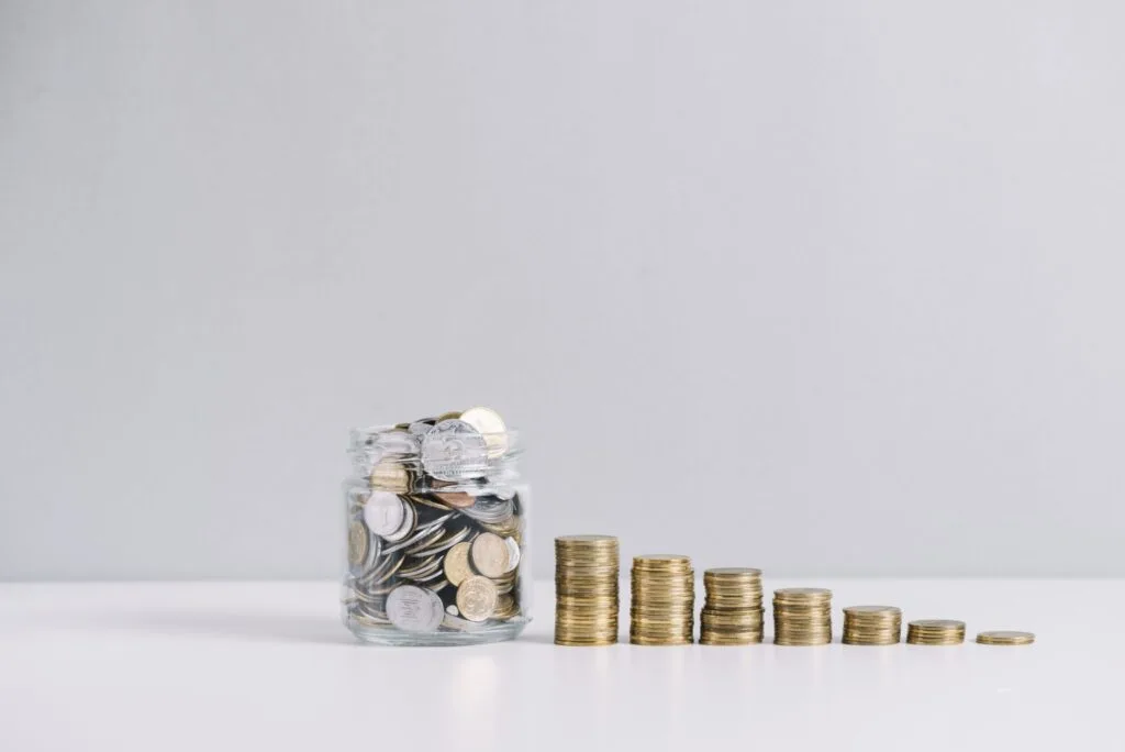 glass jar full money front decreasing stacked coins against white background 2048x1367 1